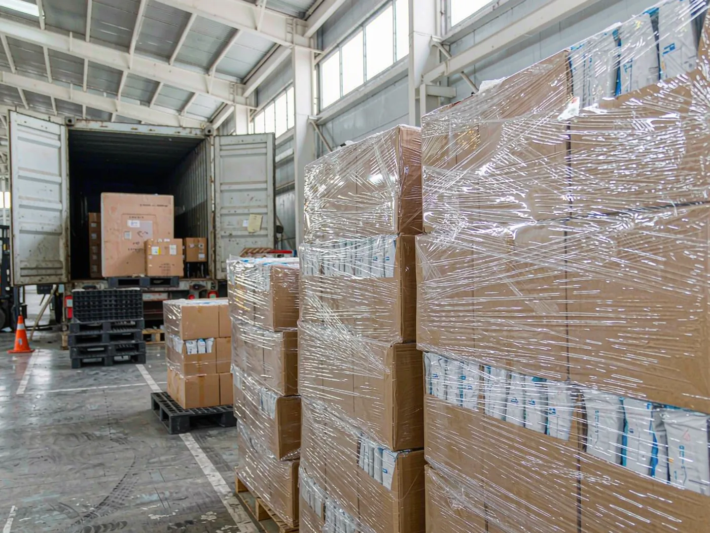 Export packing area with packaged sachets on pallets being prepared for shipment
